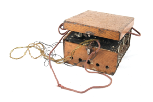 Hjemmelaget radio i treboks, med tilhørende kabler og hodetelefoner.